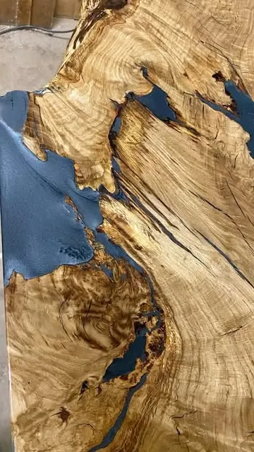 Instagram-Beitrag: Tischplatte aus Massivholz mit Rissen, gefüllt mit blauem Epoxidharz