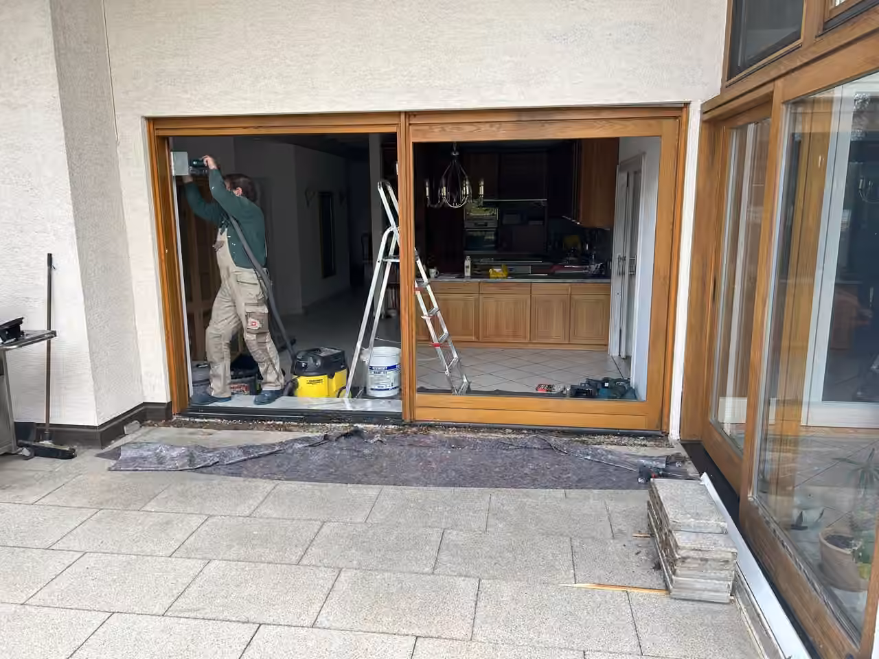 Mitarbeiter montiert eine Holz-Schiebetür zur Terrasse