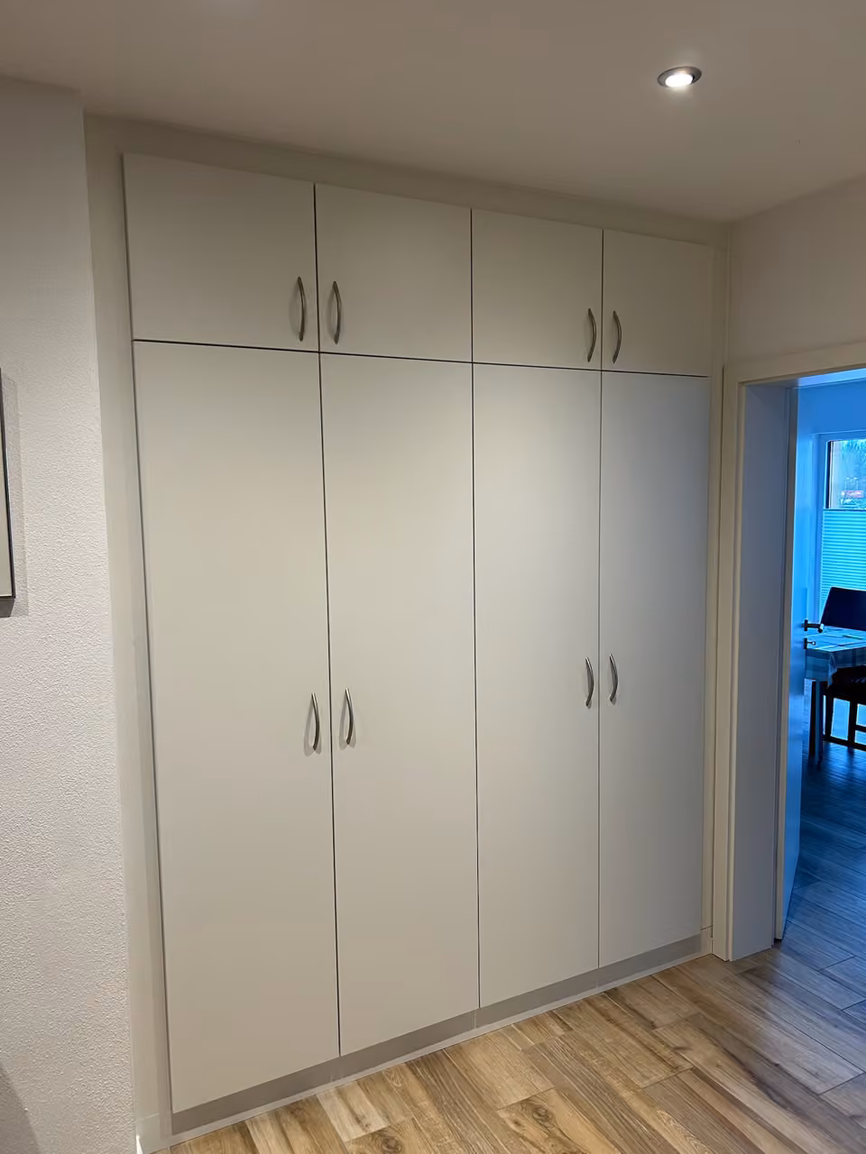 Weiße raumhohe Einbauschrankwand in einem Flur