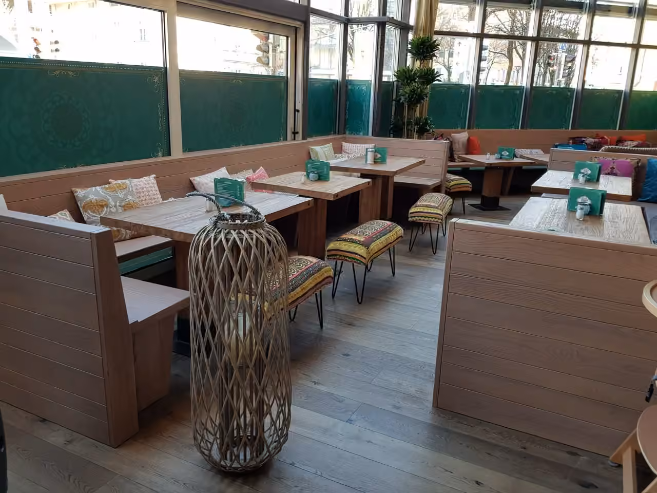 Gastronomie mit Sitznischen aus Holz, Tischen und einer großen Bodenlaterne