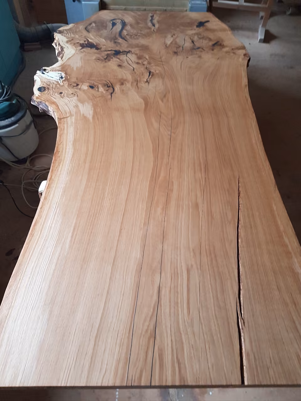 Lange Holzbohle mit natürlicher Baumkante und rötlicher Maserung