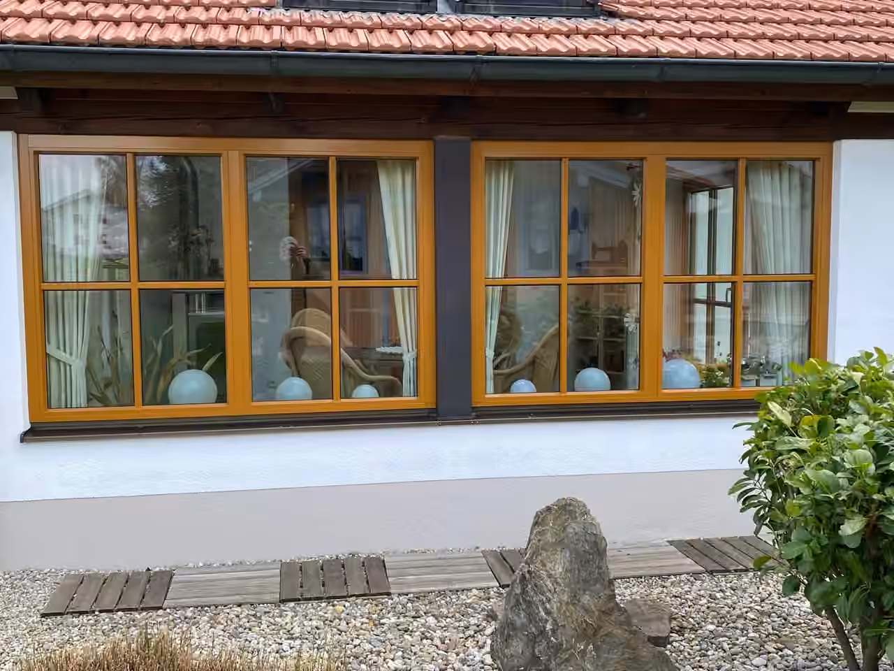 Zwei Holzsprossenfenster in Eiche an einem Haus mit Ziegeldach